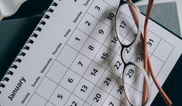 calendar displaying the month of january with a pair of glasses on top
